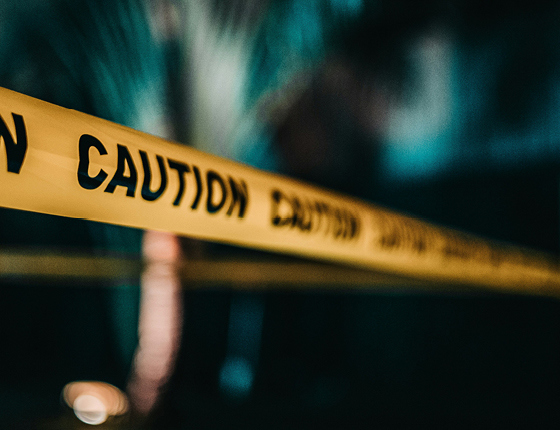 een oranje kleurig politie lint met daarop het woord 'caution'. De banner wordt gebruik bij het artikel van Teeuwissen over oplichting aan deuren 